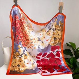 Detail of floral silk scarf with red and yellow flowers and orange border texture