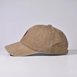 Vista laterale di un cappello da baseball kaki lavato con dettaglio ricamato a fragola.