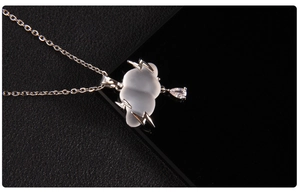 Detail of cloud-shaped pendant with silver lightning bolts and a clear teardrop gem