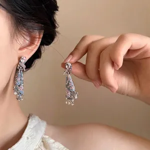 Détail de boucles d'oreilles vintage avec perles roses et bleues sur métal argent