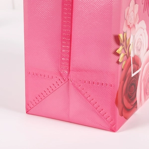 Detailed macro view of pink non-woven bag with floral print and heat-pressed bottom seal