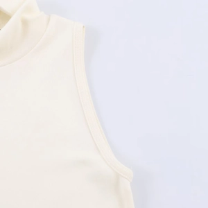 Detail view of the stitching and fabric texture on a beige sleeveless turtleneck top