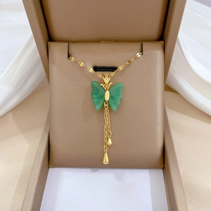 Gold-plated butterfly pendant with green jade stones and elegant tassels in a jewelry box