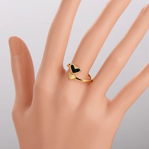 Anello aperto minimalista dorato a doppio cuore con smalto nero sulla mano di una donna