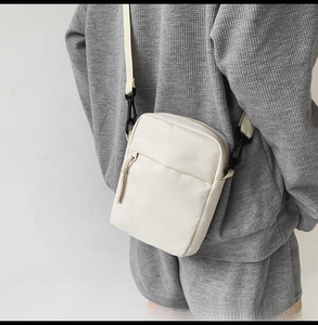 Minimalist cream white canvas crossbody bag with adjustable strap shown on model