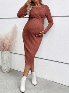 Detail of cross V-neck brick red maternity dress showing fine ribbed knit fabric texture