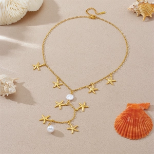 Gold starfish pendant necklace with pearls and Y-shaped chain on sandy beach background