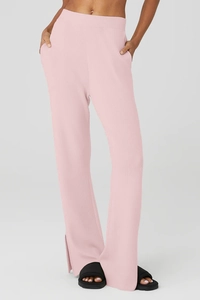Dettaglio dei pantaloni yoga in maglia a coste rosa con tasca e orlo con spacco