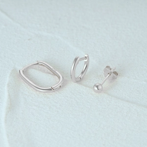 Macro shot of 925 sterling silver earring set with S925 hallmark on white stone background