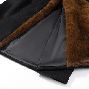 Dettaglio ravvicinato dell'elegante cappotto nero con collo in pelliccia sintetica