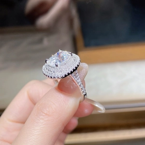 Macro shot of luxury rectangular moissanite ring with double halo and pavé diamond band