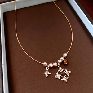 Baroque tiger eye beaded cross and iris flower pendant on a vintage gold snake chain