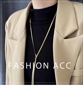 Detail of adjustable gold snake chain necklace with sliding bead and tassel on model