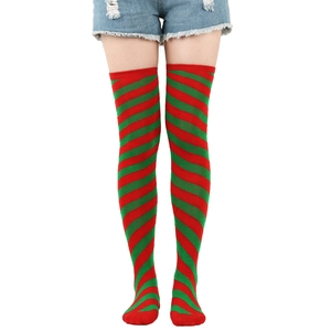 Close-up of red and green spiral striped over-the-knee Christmas socks on a model