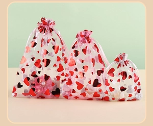 Detail of red and silver heart-patterned organza drawstring gift bags for wedding favors