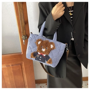 Detailed shot of blue plaid plush tote bag featuring a cute 3D brown teddy bear decoration