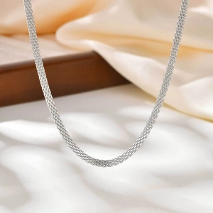 Close-up of silver mesh chain necklace showing detailed woven texture on satin fabric