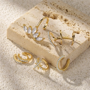 Macro detail of six gold S925 sterling silver ear cuffs with sparkling clear zircon accents