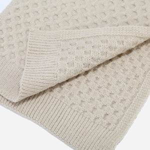 Close-up of cream white honeycomb knit texture and ribbed edge detailing on winter set
