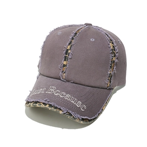 Detail of frayed edges and leopard print patchwork on purple washed cotton baseball cap