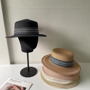 Dettaglio di cappelli di paglia bohémien in vari colori con nastro etnico intrecciato