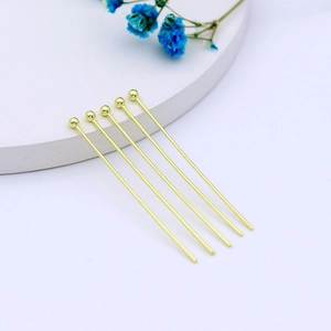 Detailed view of 14k gold-plated ball pins for handmade jewelry DIY on a white pedestal
