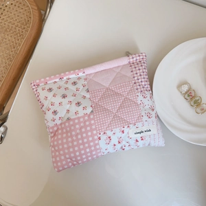 Pink floral quilted cosmetic bag with patchwork patterns and a zipper closure