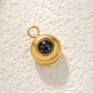 Detailed macro view of golden stainless steel round pendant with black rainbow projection stone