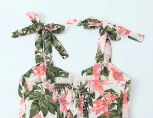 Détail de robe à fleurs avec imprimé tropical, bretelles à nœuds et dos élastique smocké