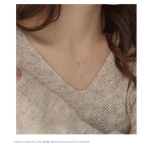 Detail view of double-layer S925 silver necklace with rainbow bar and gold vertical pendant