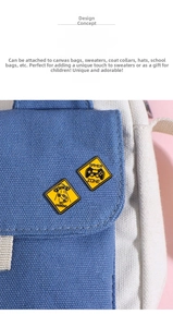 Close-up of Gamer Zone and UFO yellow enamel pins decorating a canvas backpack