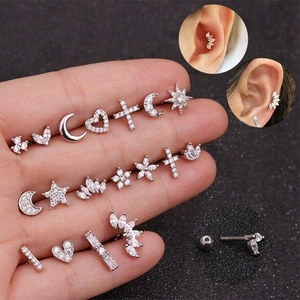 Macro shot of 18 pairs of 925 silver stud earrings with zirconia on a palm