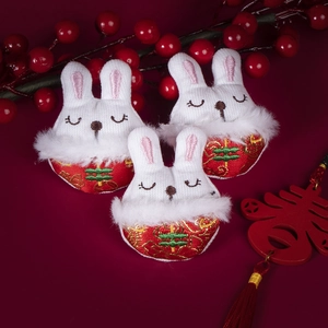 Three Chinese New Year rabbit plush pins with red embroidery and festive decorations