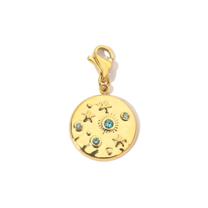 Dettaglio di ciondolo dorato con sole e stella, strass blu e chiusura a moschettone