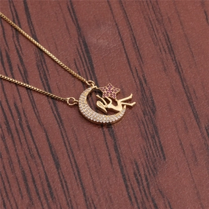 Collier déesse lune et étoile doré avec cristaux colorés sur un support en bois