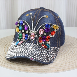 Detailed close-up of dark denim baseball cap with sparkling crystal butterfly and rhinestones