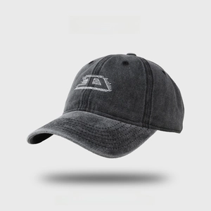 Detailed macro view of white letter D embroidery on vintage washed grey denim baseball cap