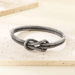 Macro shot of knot design and textured spiral patterns on retro silver finish cuff bangle