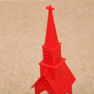 Detailed view of a red miniature church lantern with intricate window and spire patterns