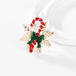 Detail of Christmas candy cane brooch with enamel bow and gold snowflake charm
