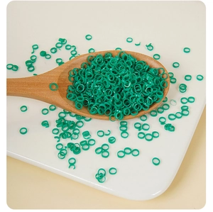 Close-up of artificial green scallion rings in a wooden spoon for DIY food crafts