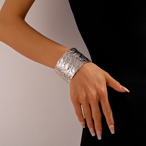 Close-up of wide hammered silver cuff bracelet with artistic textured finish on wrist