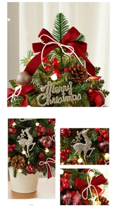 Macro detail of a 60cm mini Christmas tree with red velvet bows and LED lights