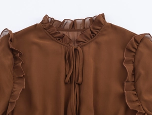 Détail du col volanté et du lien à nouer sur la robe longue marron en mousseline