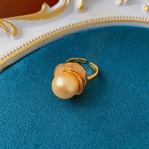 Macro shot of vintage pearl ring with zircon accents on a deep blue textured surface