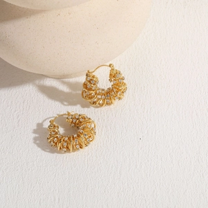 Macro shot of 14K gold plated C-shaped twisted earrings with inlaid clear zircon crystals