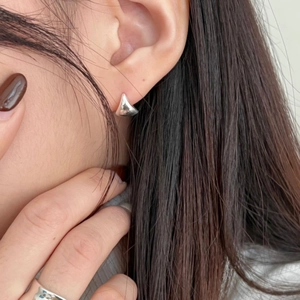 Close-up of 925 sterling silver geometric triangular hoop earring on a model