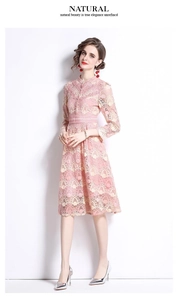 Détail de la robe en dentelle rose montrant la broderie florale et le col montant chic