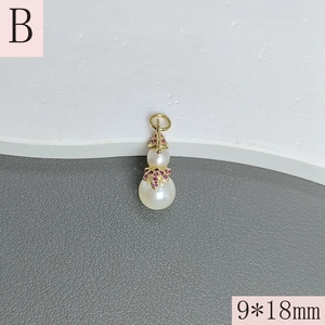 Macro view of a 9x18mm calabash pearl pendant with red zircon and golden closure