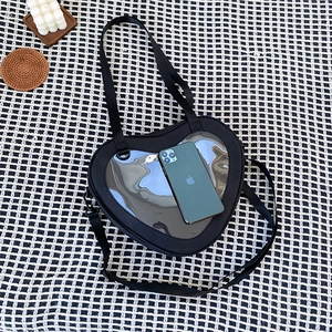 Detail shot of heart-shaped black ita bag with clear window on checkered background